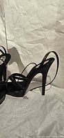 Side view of black strappy platform high heel sandal showing heel height and straps