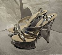Side view of both shoes showing silver straps, clear platform and heel