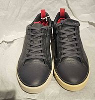 Top view of both sneakers showing laces, leather texture, and outsole color