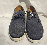 Front view of pair of grey suede Lacoste shoes showing uppers, laces, stitching, and white midsole