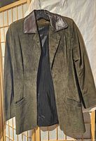 Front view of olive suede jacket showing collar, pockets, and lining