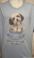 Front view of light blue Gildan T-shirt showing dog-in-teacup graphic and slogan
