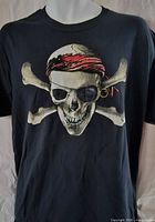 Front view of black T-shirt displaying pirate skull and crossbones graphic