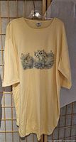 Front view of pale yellow kitten graphic T-shirt on hanger