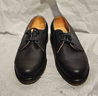 Front view of both shoes showing black leather uppers and lace arrangement