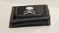 Front view of black wallet showing skull graphic and stitching