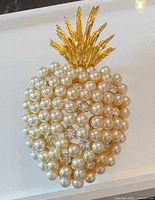 Front view of gold-tone pineapple brooch showing faux pearls and rhinestones