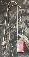 Full view of sterling silver snake chain with pink crystal pendant