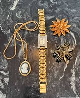 All four jewellery pieces arranged on dark stone surface