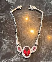 Full view of sterling silver bracelet showing red stones and clasp