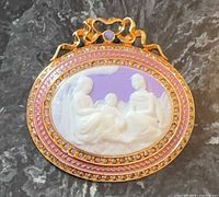 Front view of oval gold-plated purple cameo brooch with rhinestone and enamel border