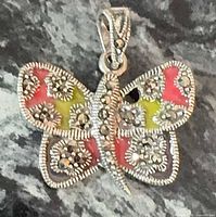 Front view of sterling silver butterfly pendant showing marcasite stones and enamel colors