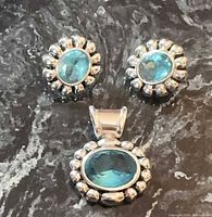 full view of matching earrings and pendant showing design and stones
