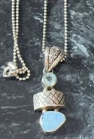 Front view of pendant and portion of ball chain showing opalite, aquamarine, bail, and clasp