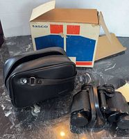 Binoculars with case and original box displayed on surface