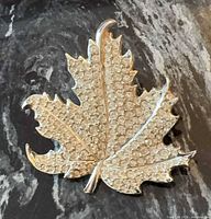 Front view of rhinestone maple leaf brooch