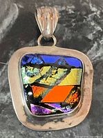 Front view of sterling silver pendant with multicolour dichroic glass