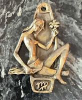 Front view of entire pendant showing figural design and Virgo glyph