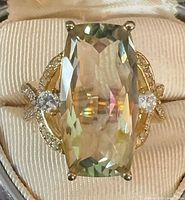 Top view showing elongated cushion-cut green amethyst, CZ accents, and prong setting