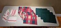 Overall group showing red plaid placemats, green placemats, white napkins