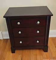 Front view of dark cherry nightstand, closed drawers