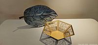Leaf-shaped patinated platter and gold-tone hexagonal cutout bowl on table