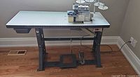 Full view of serger mounted in table with stand and motor