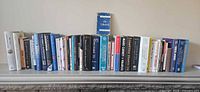 Full panoramic view of the complete row of roughly 40 of the 64 books on a mantel