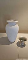 Large white plaster vase and small silver mercury-glass style vase side by side