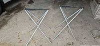 Pair of Talic folding stools fully opened and standing side by side on ground