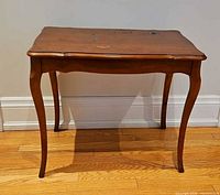 Full view of hardwood side table showing cabriole legs and overall shape