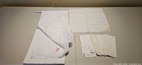 Tablecloth folded on hanger and six napkins arranged