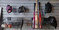 Wall rack with 3 bats, 4 gloves, basket of balls