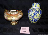 Front view showing both items: footed bowl with gilt handles and lidded ginger jar