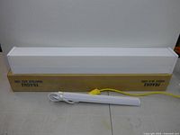 36-inch fluorescent fixture on shipping box with corded light in foreground