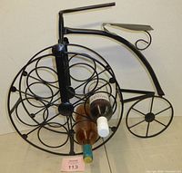 Full view of bicycle-shaped metal wine rack front side with sample bottles inserted