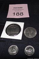 Overview of all four coins including one dollar in cardboard flip and two 1967 nickels