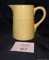 Front view of yellow wheat pattern Medalta jug