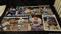 Eight 1970s Vancouver Canucks game magazine programs laid out showing cover images
