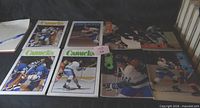 Eight Vancouver Canucks 1970s game programs laid out on table