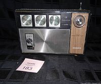 Front view showing speaker grille, controls, band indicators, brand name