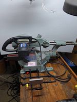 Full view of King Canada sliding compound miter saw on workbench with power cord