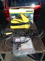 Full lot showing pressure washer, cords, hoses, manual, box