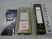 Three retail-packaged golf gloves: FootJoy SciFlex, Top Flite XL Tour, King Cobra
