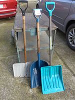 Front view of three shovels standing upright