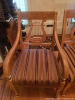 Front view of lyre-back armchair showing striped seat and overall design