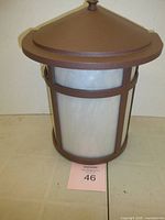 Front view of cylindrical wall lantern showing frosted diffuser and bronze frame