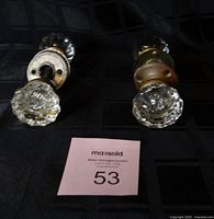 Two glass door knob assemblies showing clear faceted knobs and metal rosettes