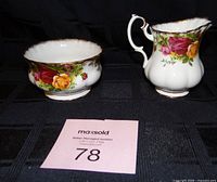 Both the creamer and sugar bowl side by side