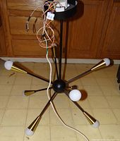 Chandelier unlit showing black body, brass cones, wiring, LED bulbs